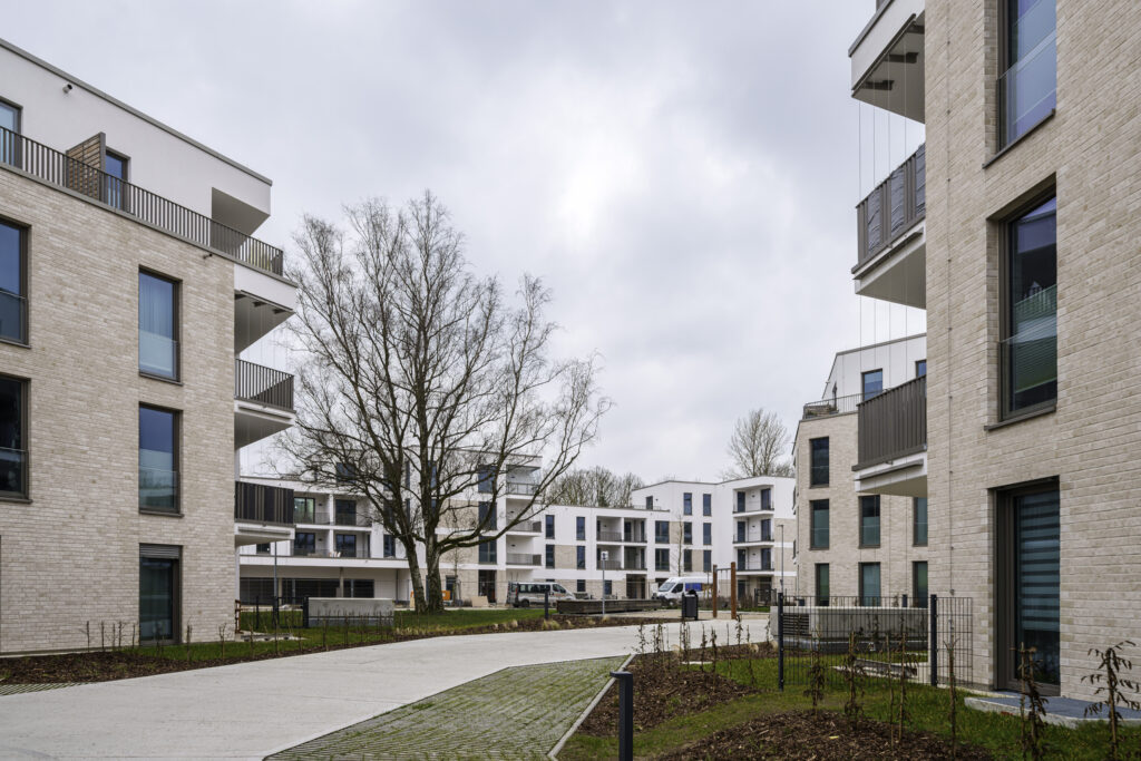 Koberststraße DOMUSIMAGES Das neue Wohnviertel in der Thierfelder- und Kobertstraße im Hansaviertel. Die neuen Häuser haben weiße Fassaden, die zum Teil sandsteinfarben verklinkert sind. Durch das Quartier verläuft eine Straße, auf einer Grünfläche steht ein alter groß gewachsener Baum.