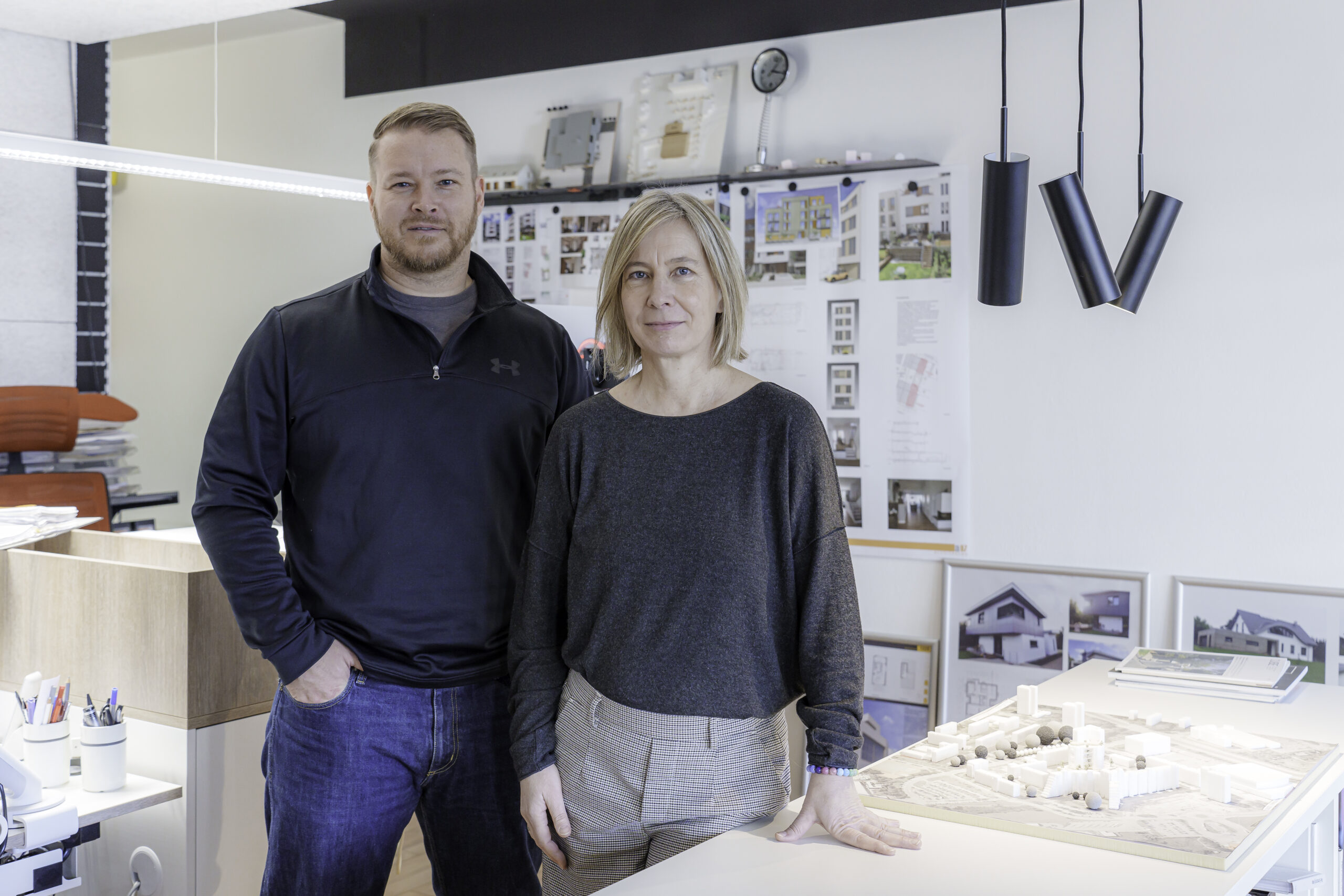 Dana Bandau - blonder Bob, grauer Pulli und graue Hose - steht neben Andreas Löper - mittelblond, Bart - dunkler Pulli und Jeans - in ihrem Gemeinschaftsbüro in der August-Bebel-Straße 32e.