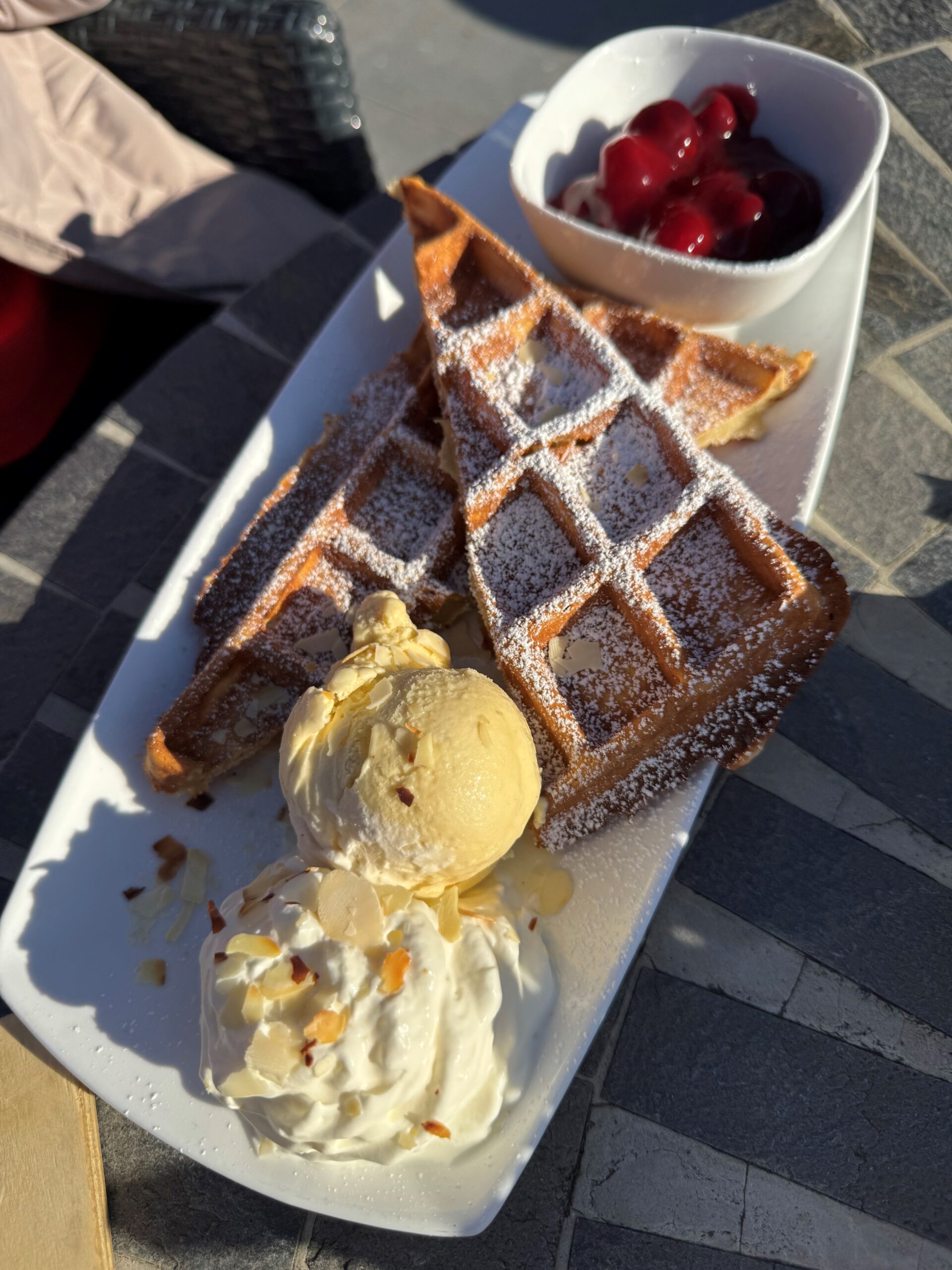 Belgische Waffeln DH Knusprig gebackene Belgische Waffeln mit einem Schälchen Kirschgrütze, Vanille-Eis und Sahne.