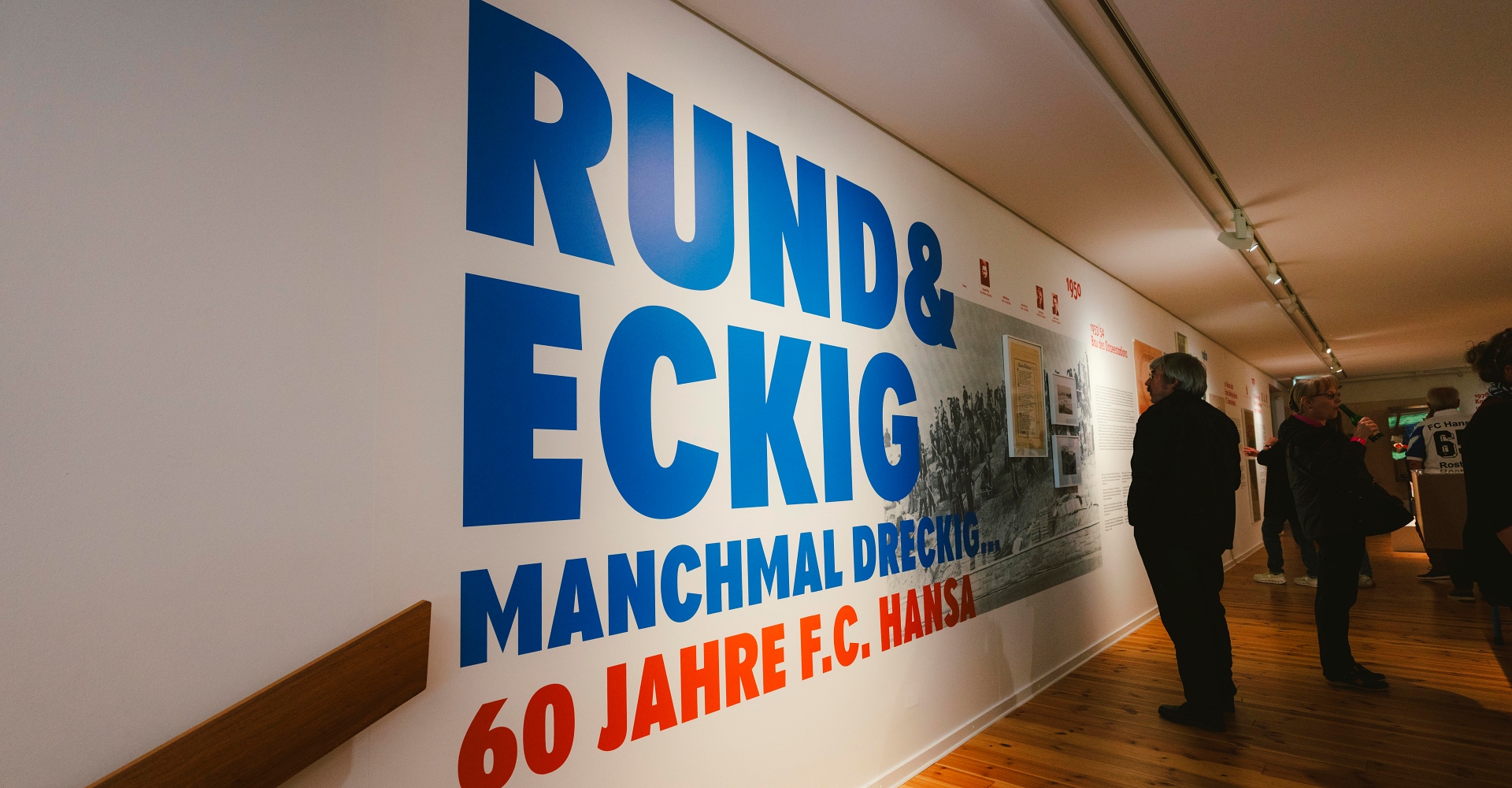 Die blaue Aufschrift RUND & ECKIG, MANCHMAL DRECKIG zur Ausstellungseröffnung 60 Jahre FC Hansa in der Kunsthalle Rostock