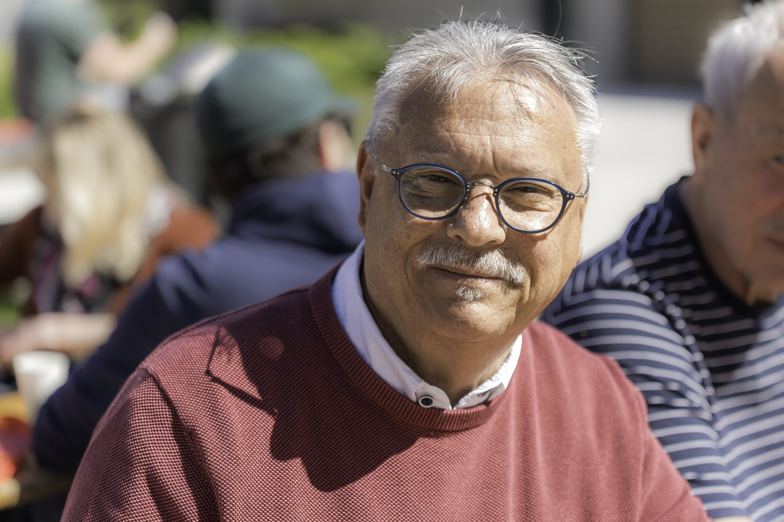 Helmut Zeisler Helmut Zeisler, WIRO-Mieter in der Thierfelderstraße, graue Haare, blaue Brille, roter Pullover lächelt freundlich beim Mieterfest.