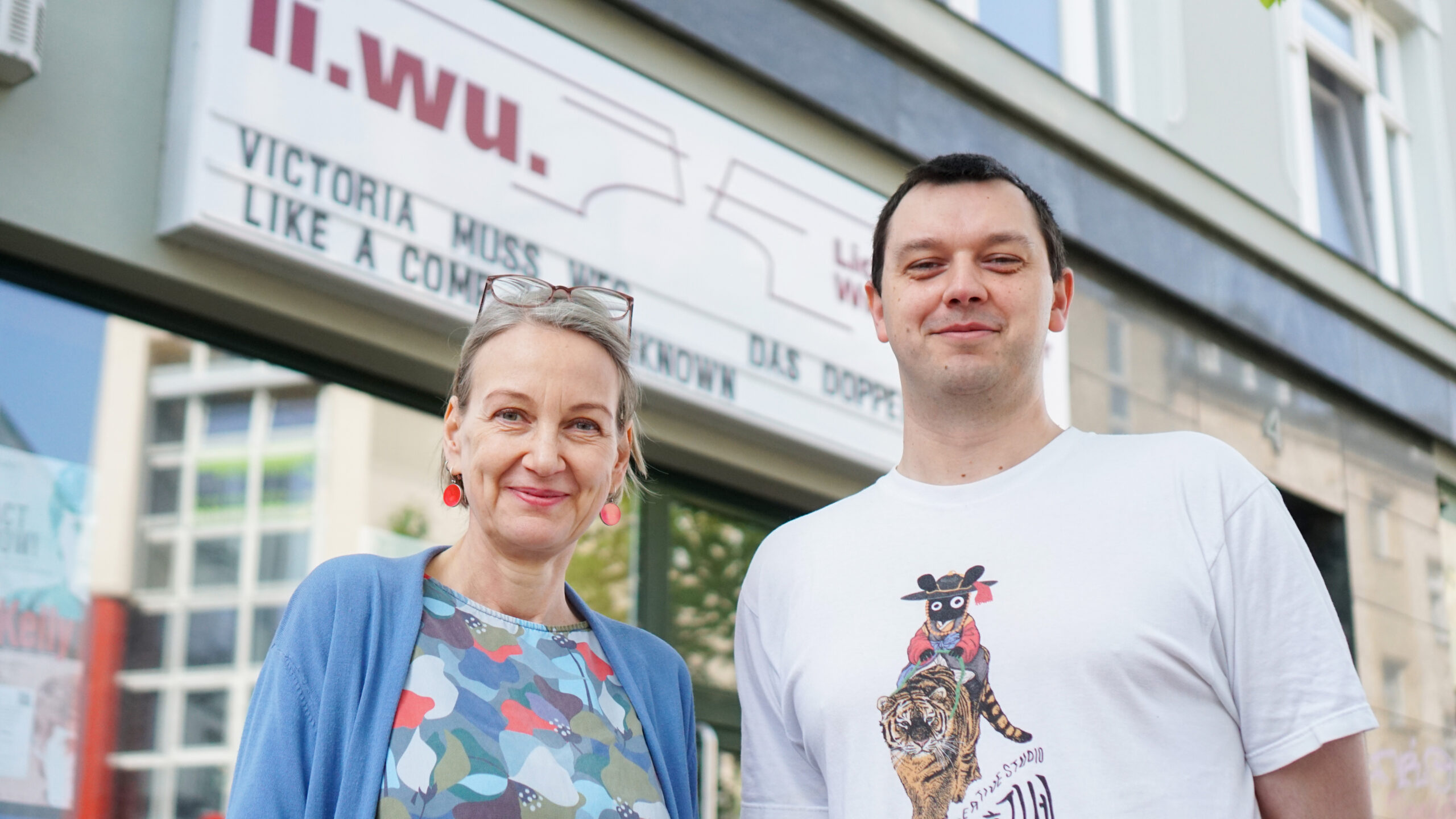 Dr. Anne Kellner und Max Roth vom li.wu. stehen vor dem Eingang des Rostocker Lichtspieltheaters Wundervoll.