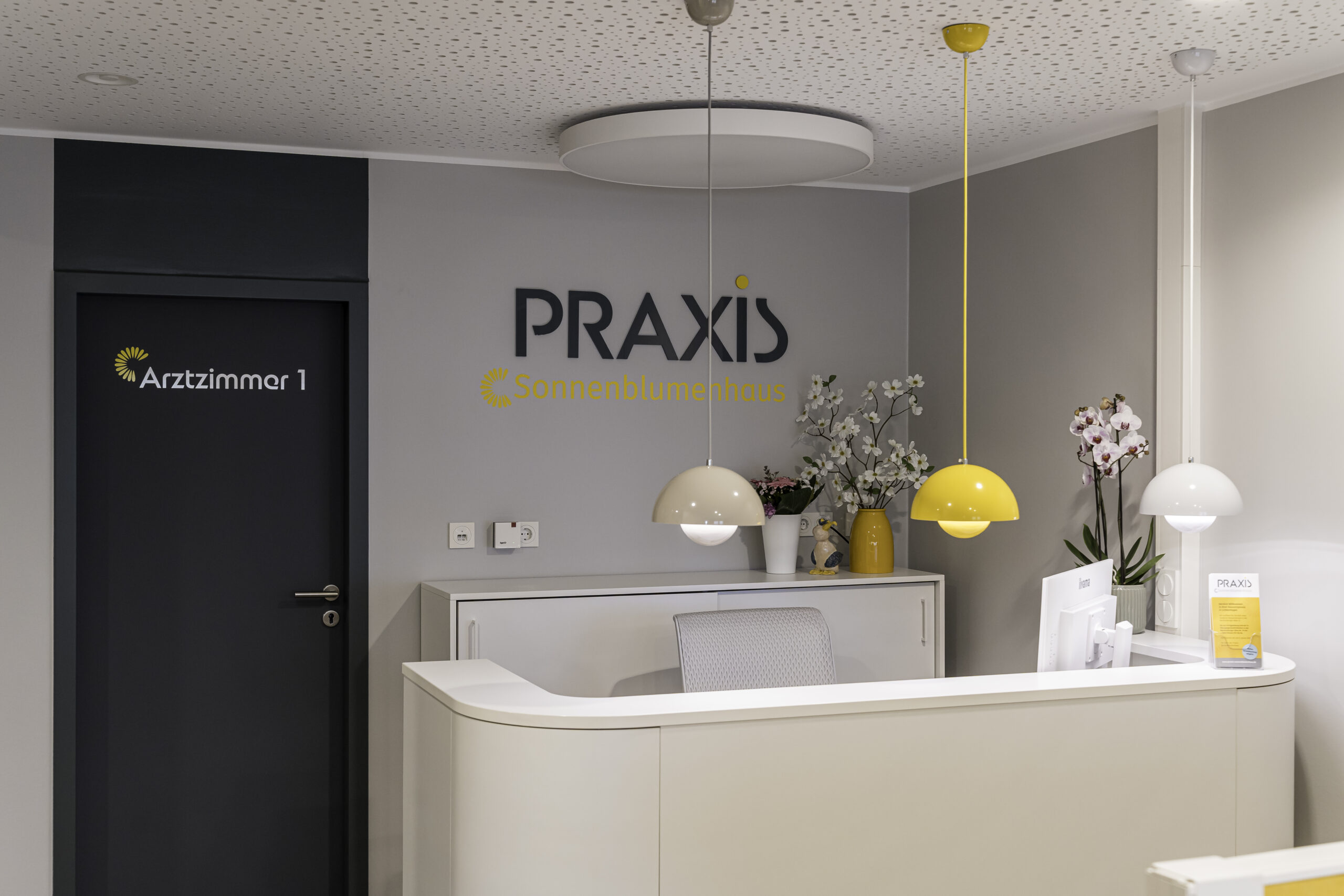 Tresen Praxis Stövesand In der Arztpraxis Stövesand gibt es passend zum Sonnenblumenhaus einen liebevoll gestalteten Tresen in grau-beige mit gelben Akzenten.