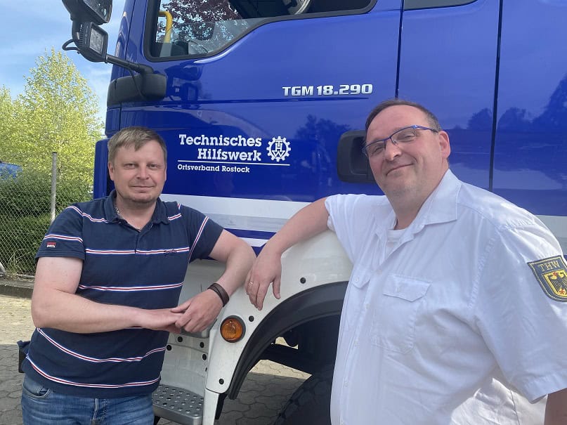 Mark Krüger (links) und Jens Becker vor einem THW-Fahrzeug.