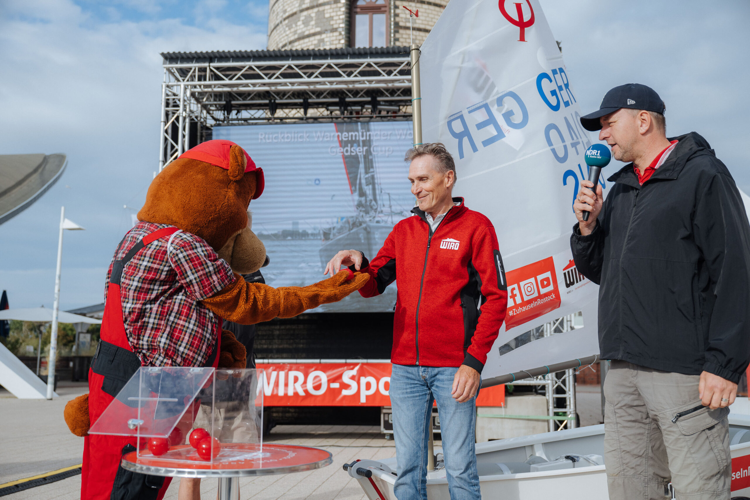 DSC_7520 Optimisten-Verlosung - von links nach rechts: Maskottchen Bodo-Bär, WIRO-Geschäftsführer Ralf Zimlich und Moderator Steffen Baxalary