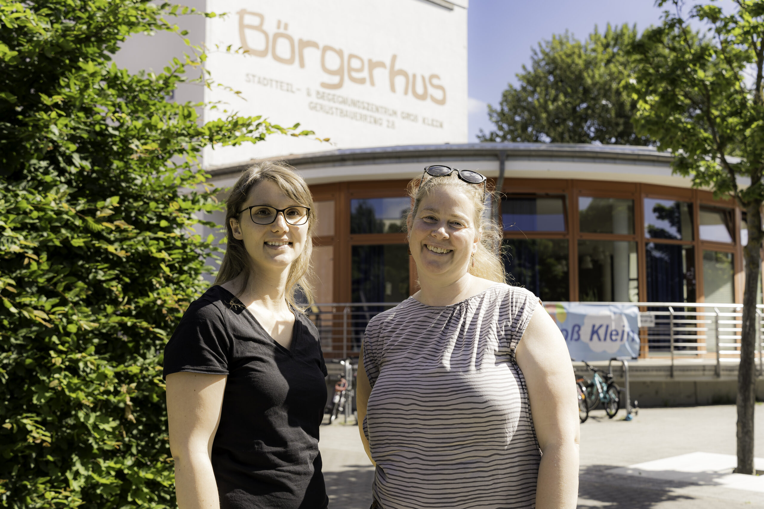 Kristin Taust und Lucia Ziegler stehen lachend vorm Börderhus in Groß Klein.