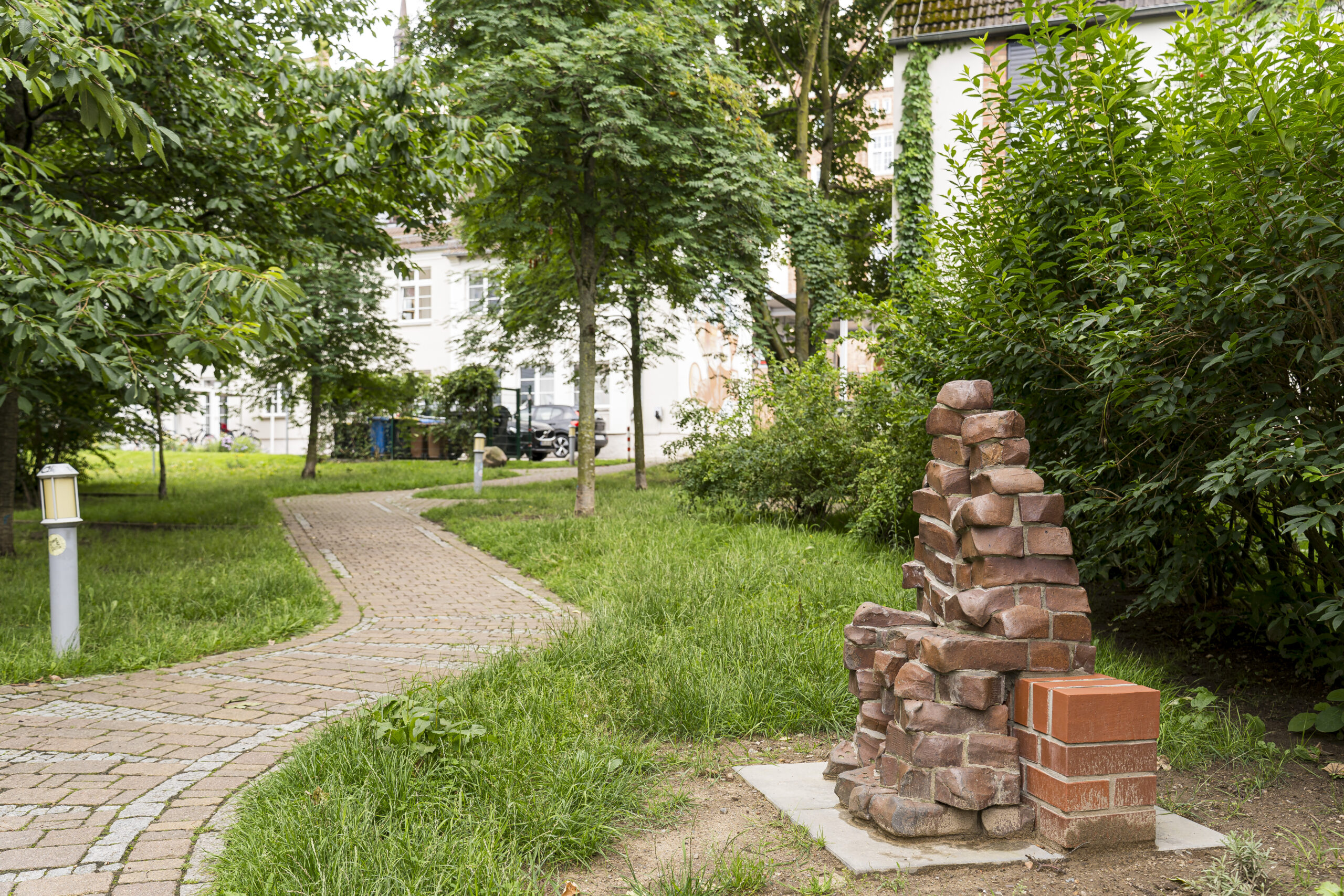 Die Backsteinskulptur "Die Liebenden" verschönern nun den begrünten Innenhof Pläterstraße/Wokrenterstraße.
