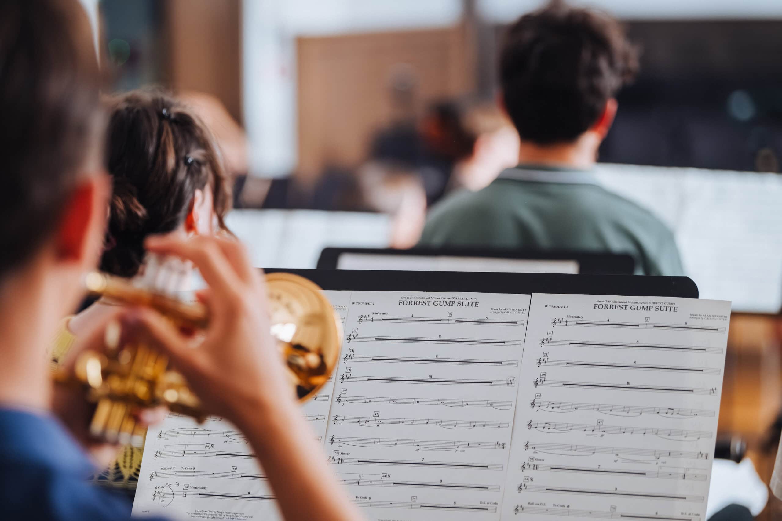 Hinter Notenblättern sitzt ein junger Trompetenspieler vom Rostocker Jugendsinfonieorchester.
