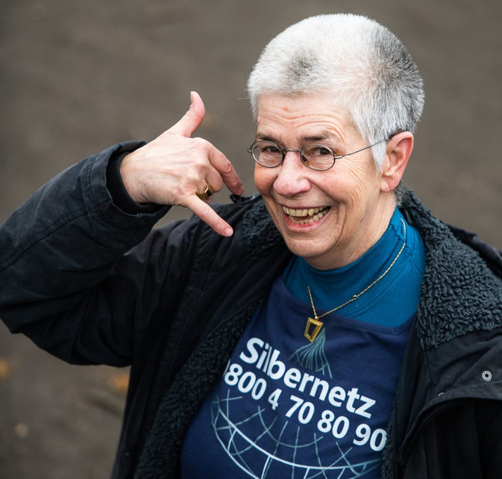 Elke Schilling Silbernetz-Initiatorin - Berlin 3 / 2021 Foto: Wolfgang Schmidt Elke Schilling hat Silbernet z e.V. gegründet. Die selbst silber-graue Dame imitiert auf dem Foto einen Telefonanruf.