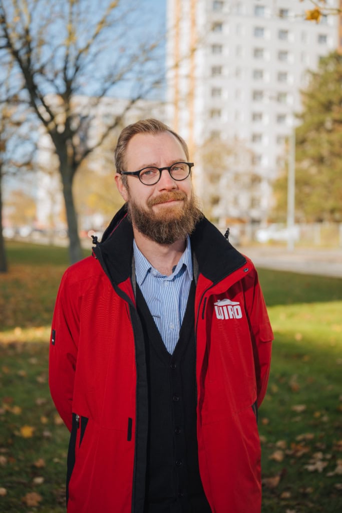 Tobias Hegewald, Brille, Vollbart, rote WIRO-Jacke, gehört zum Vermietungsteam der Warnowallee 23a.