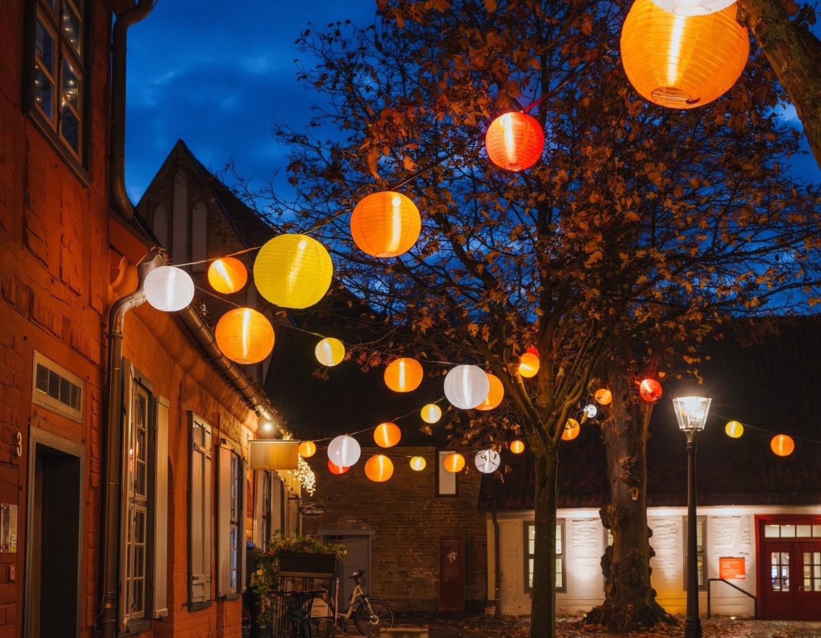 Adventsbeleuchtung mit bunten Laternen im historischen Klosterhof.