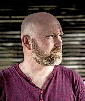 Stefan Härtel, Buchblogger, Glatze und Bart, empfiehlt und liest professionell Bücher.