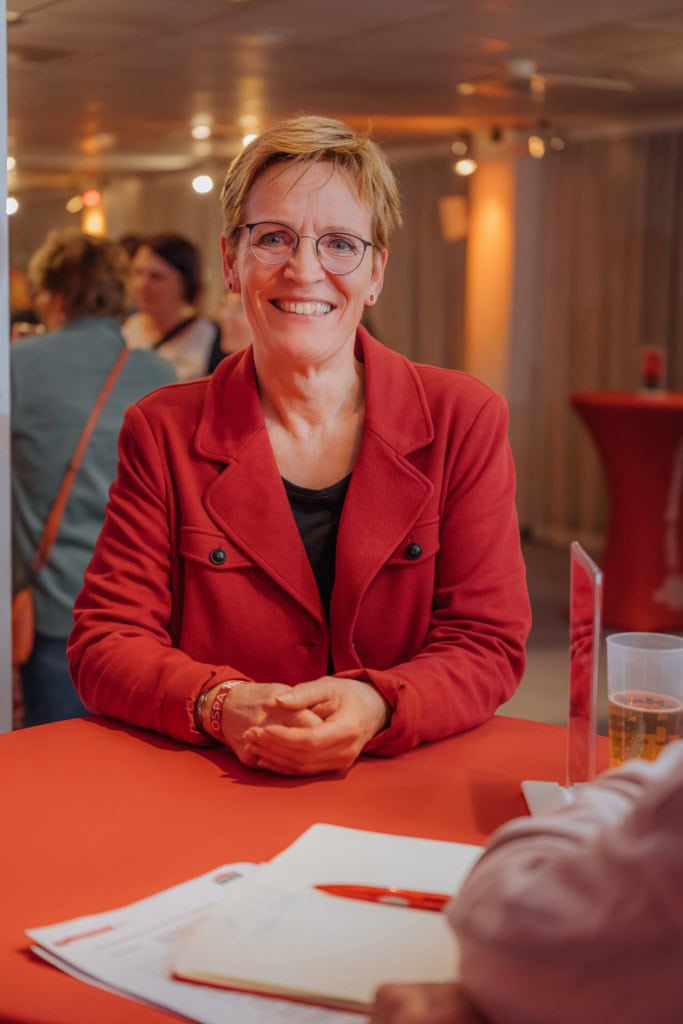 Andrea Wehmer, kurze Haare, Brille, roter Blazer, ist Rostocks Kinder-, Jugend- und Familienkoordinatorin und unterstützt die Initiative Lernen, aber satt.