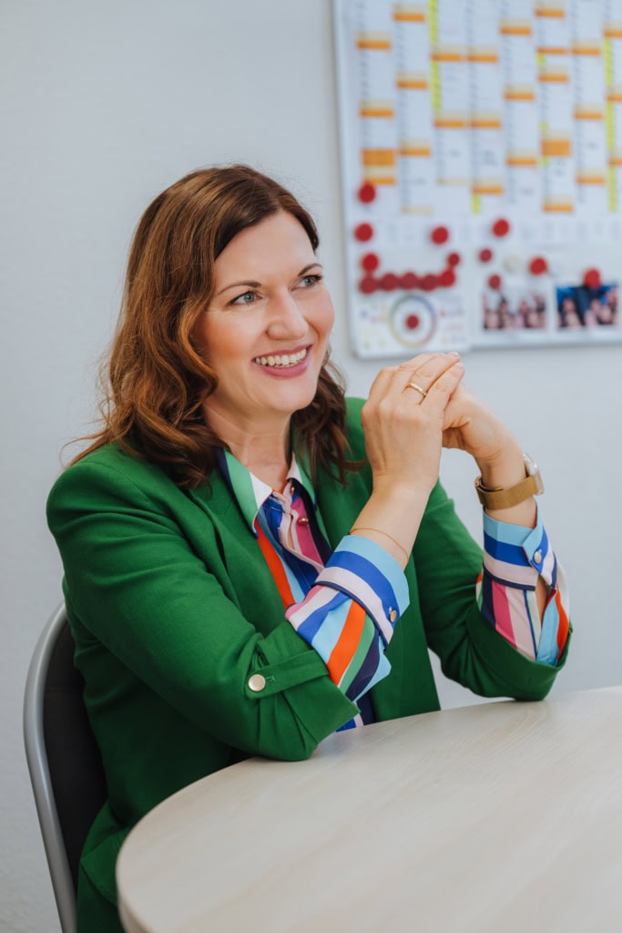 Geschäftsführerin Karina Gradke, lange braune Haare, bunt gestreifte Bluse unter grünem Blazer, leitet die WIRO-Tochter "Pflege in Rostock".