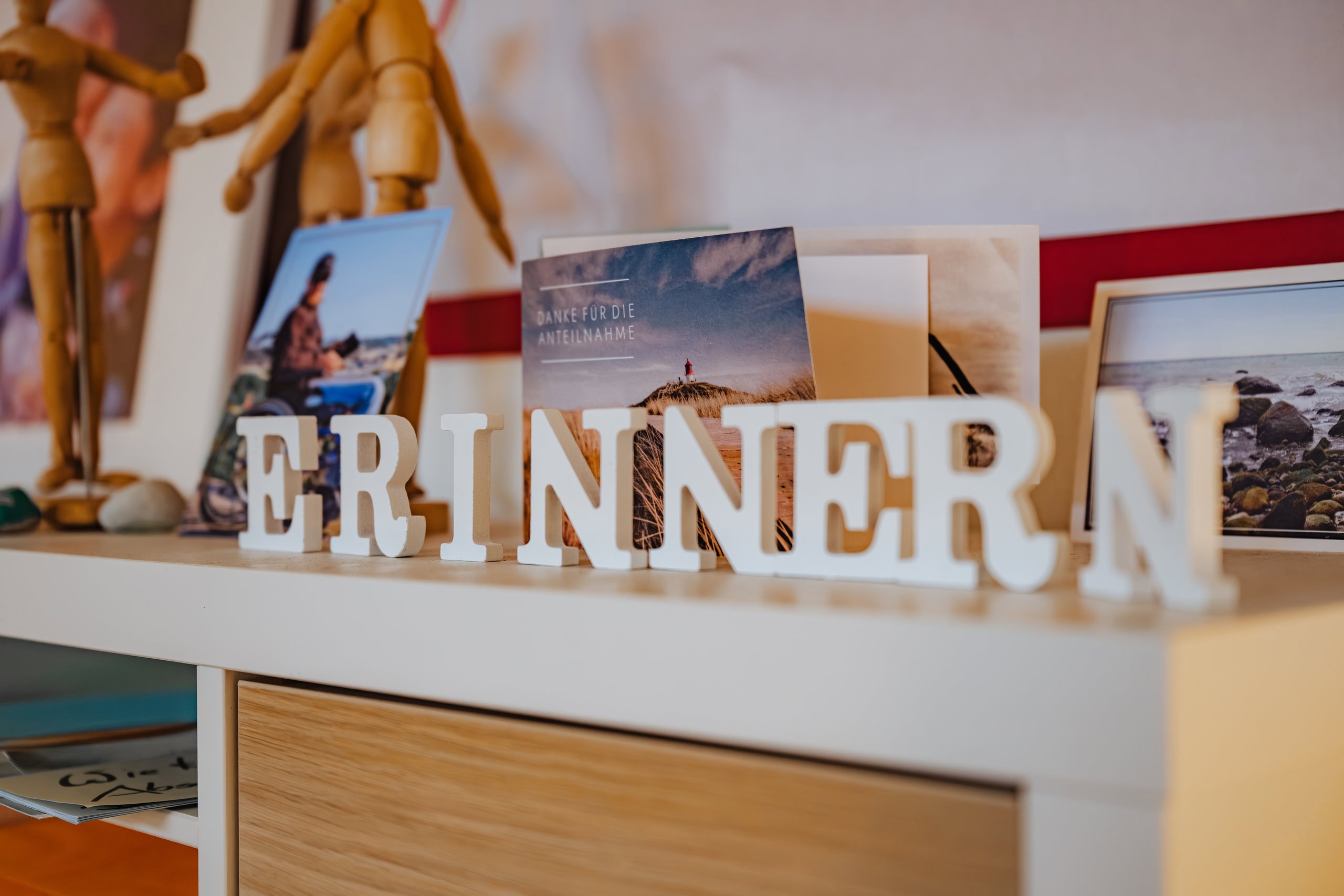 Kinderhospiz OSKAR Das Wort ERINNERN im Rostocker Kinderhospiz OSKAR neben Fotos und Karten, die an Verstorbene erinnern.