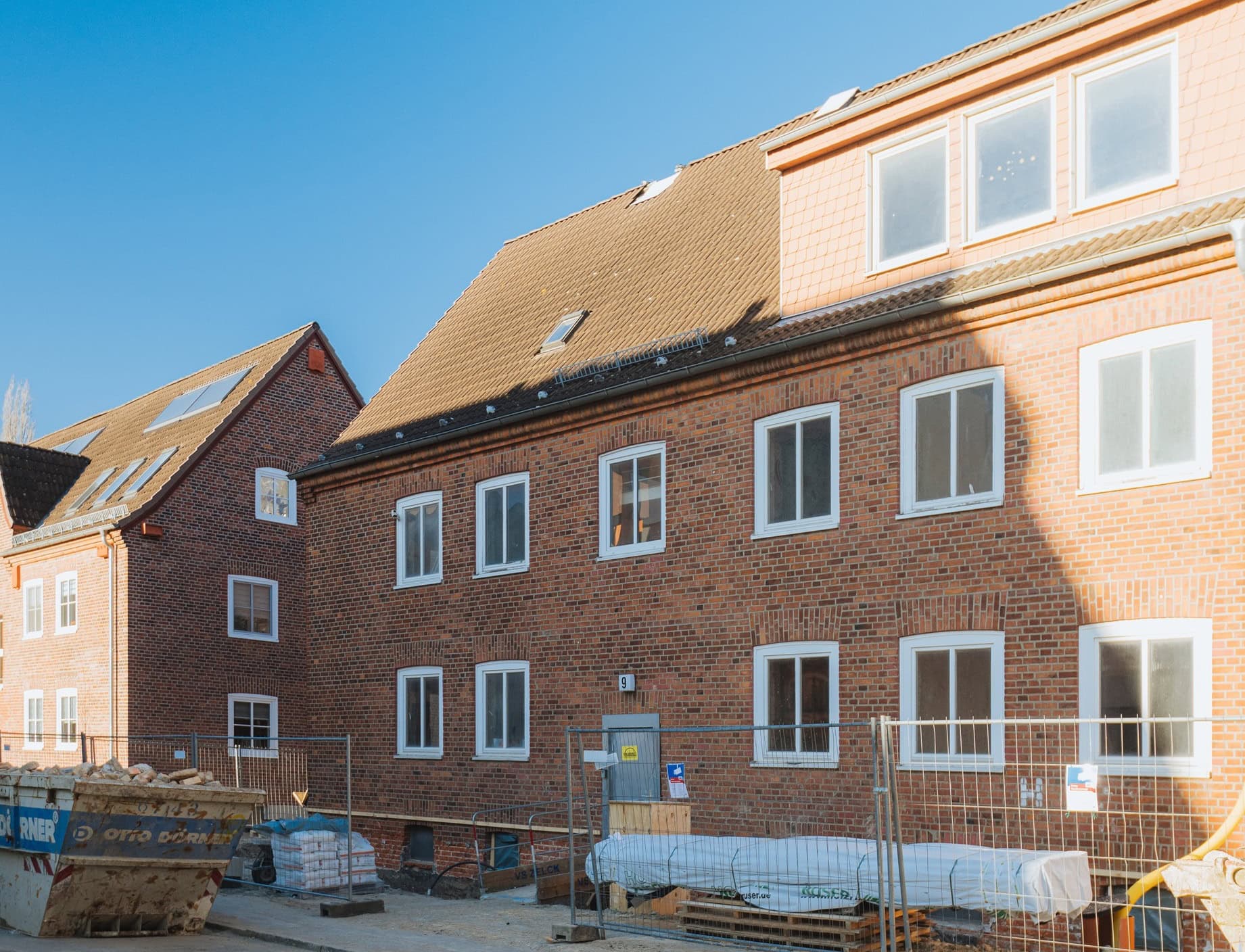 Das Haus Nummer 9 in der Lortzingstraße in Rostock Warnemünde, Bauzäune stehen davor, ein Cotainer mit Bauschutt