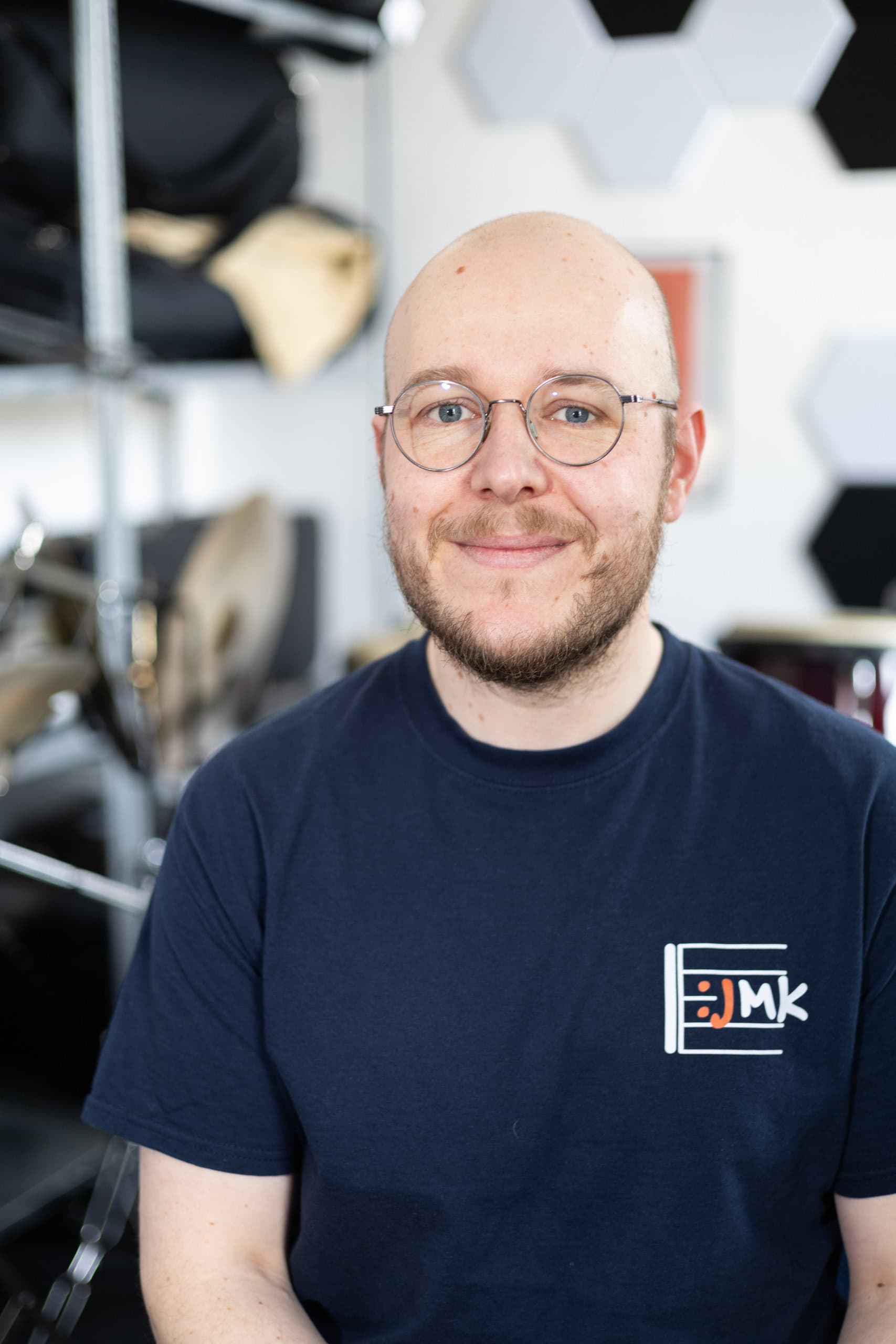 Tony Enders, Musikalischer Leiter des Jugend-Musikkorps Rostock e.V., Glatzkopf, freundliches Lächeln, trägt eine Brille