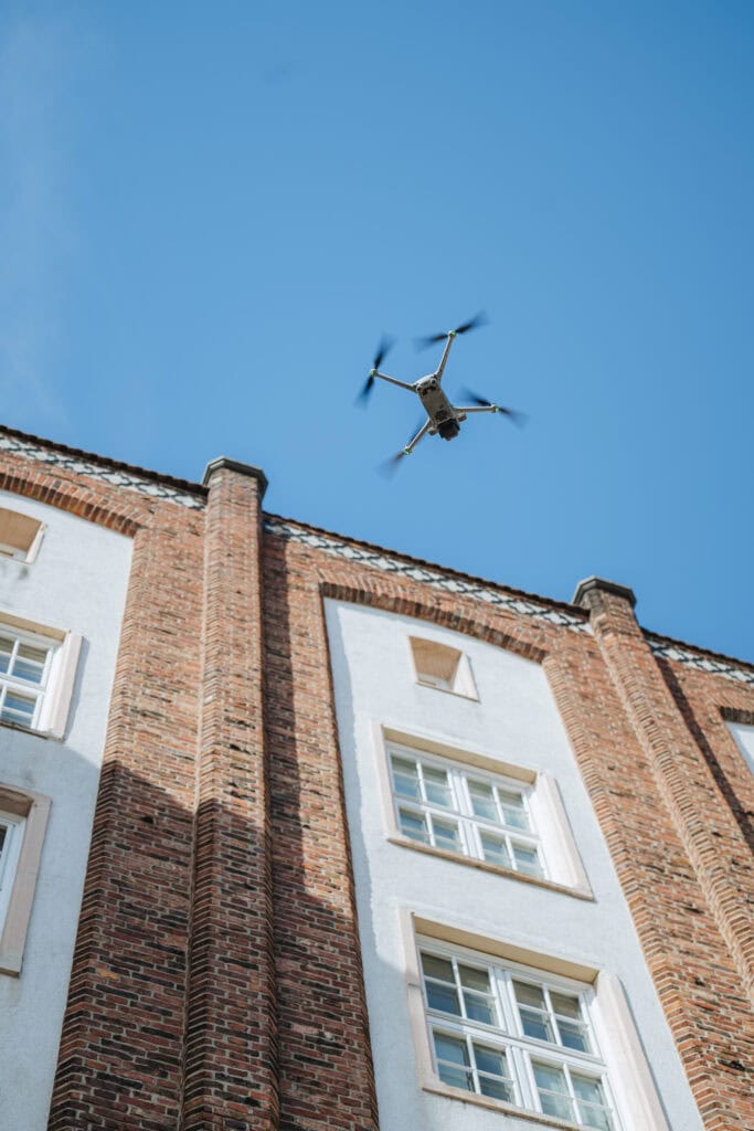 Eine Drohne überfliegt ein Haus in der Rostocker Langen Straße, um die Fassade zu untersuchen.
