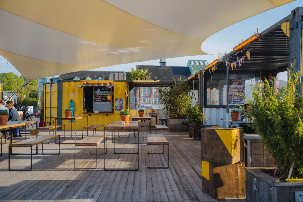 Auf Liegestühlen an der Kaikante chillen, mit einem kühlen Getränk in der Hand. Das Hafendommel-Team bereitet in seinem quietschgelben Container auf der Haedgehalbinsel nicht nur leckere Cocktails und Kleinigkeiten zu, sondern sorgt auch für Leben im Stadthafen: beispielsweise mit Jazz-Jam-Sessions, Swing-Tanzkursen, Yoga-Stunden.